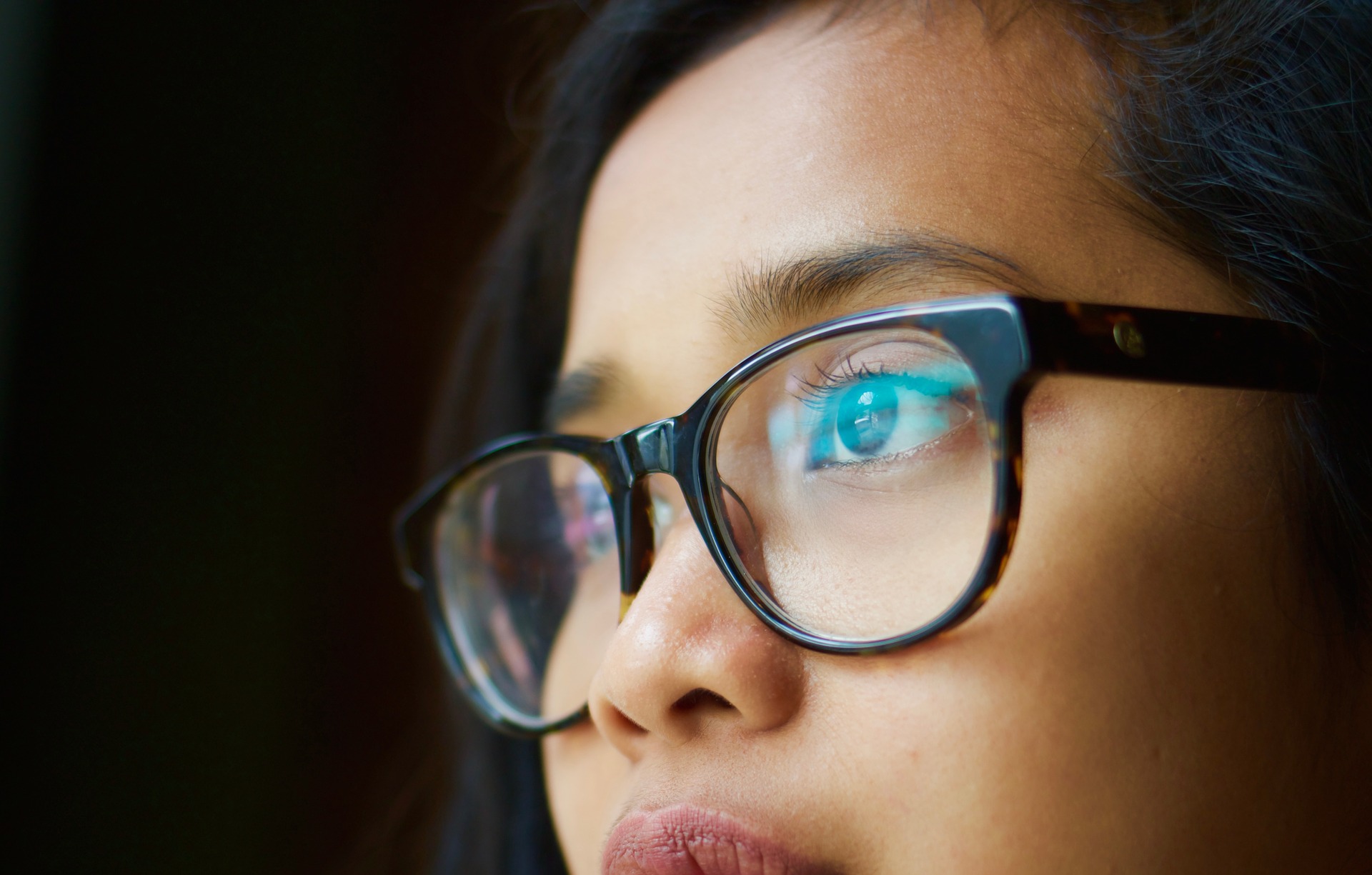 woman wearing glasses while thinking